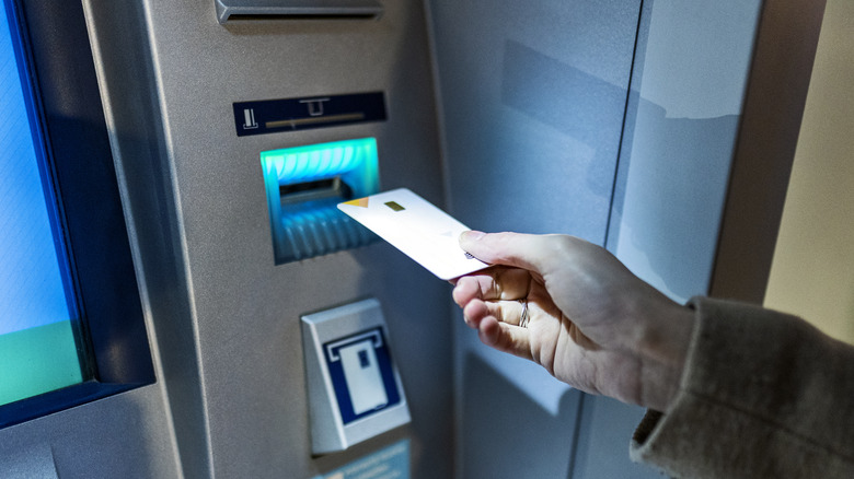 Person inserting card into ATM machine