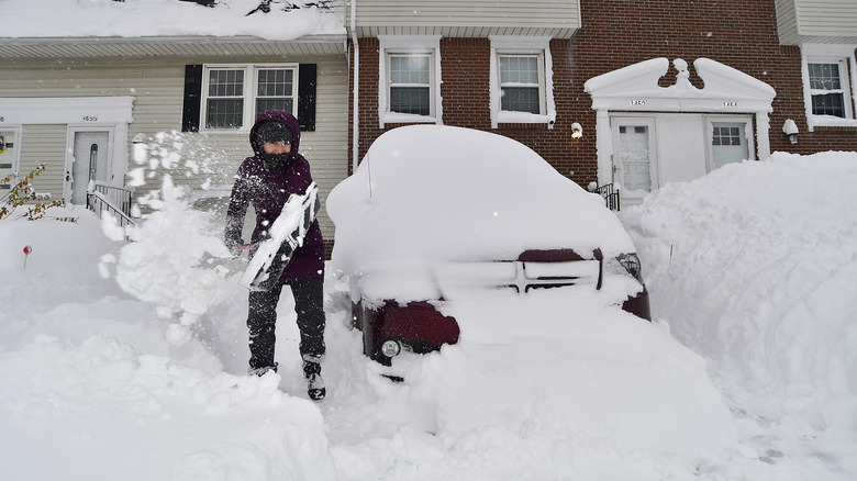 Woman shovels snow from driveway