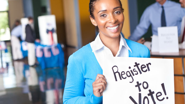 woman holding register to vote sign