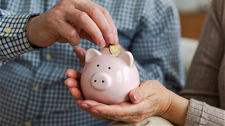 Putting coin in piggy bank