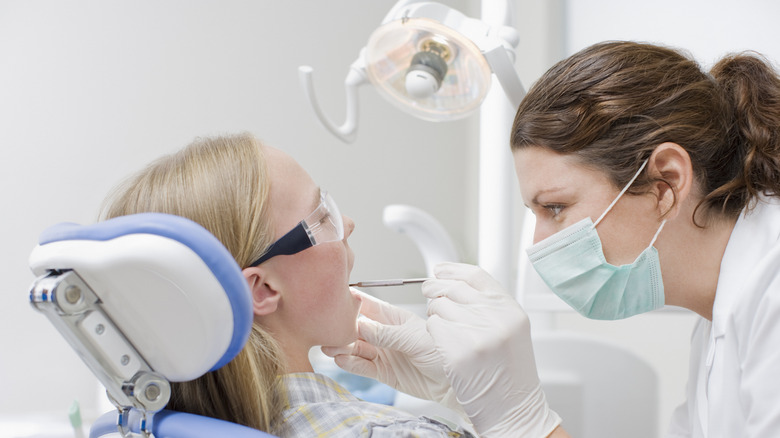 A hygienist checking a patient's teeth
