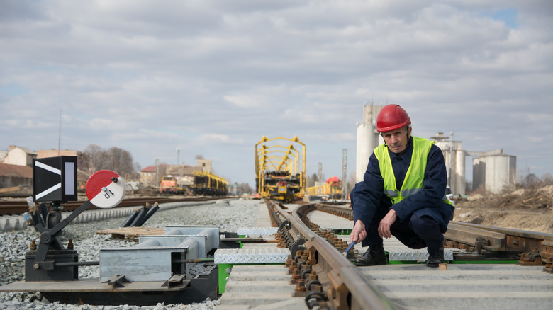 A man inspecting train tracks