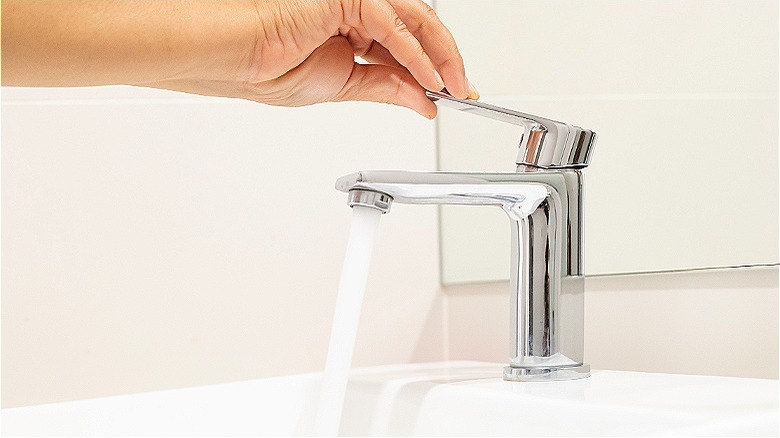 a hand operating water faucet