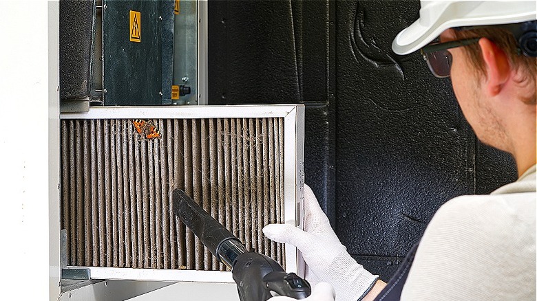 person cleaning furnace filter