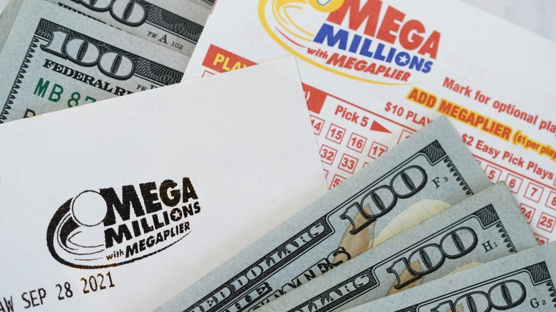 Mega Millions lottery ticket with hundred dollar bills