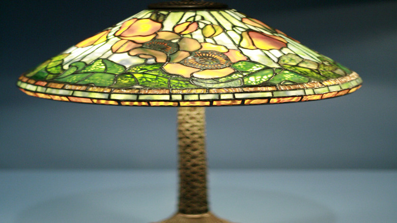 Close-up of a Clara Driscoll Tiffany lampshade design, featuring yellow flowers and green leaves.