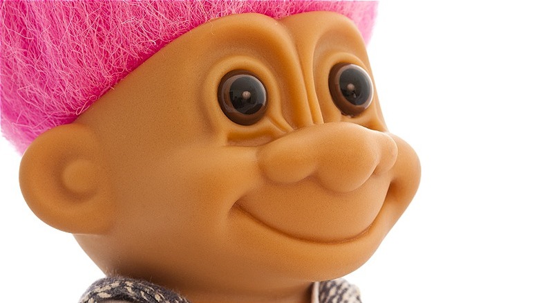 Close-up of a troll doll face with pink hair