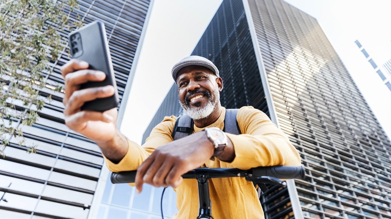 Man taking photo with skyscraper