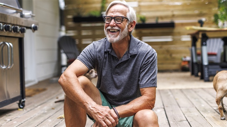 Man smiling, sitting on porch