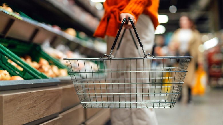 Grocery shopper holding empty basket