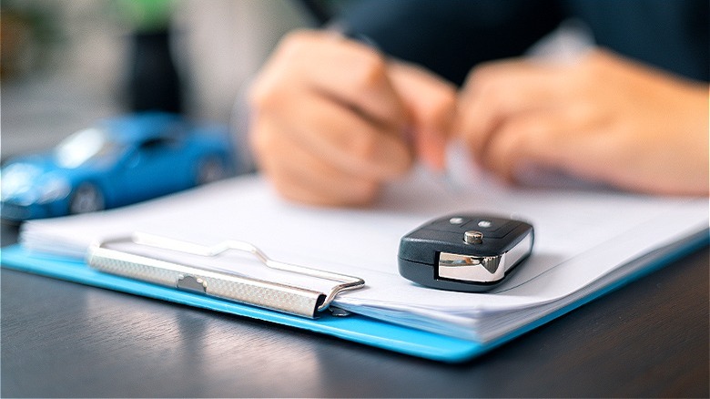 Car salesperson with vehicle paperwork 