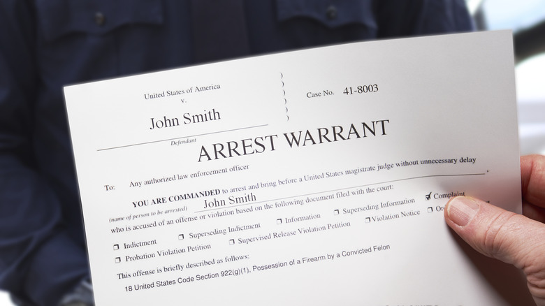 A man holding an arrest warrant