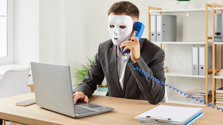 A masked man on a phone