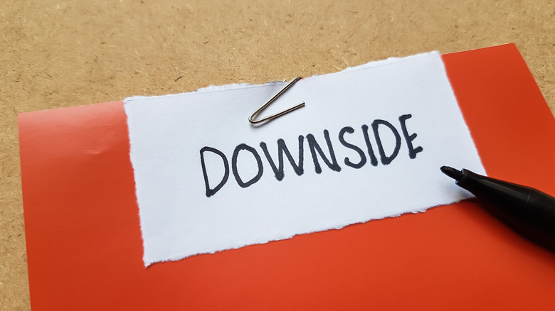 An orange folder with a small piece of white paper clipped to the top that reads: Downside.