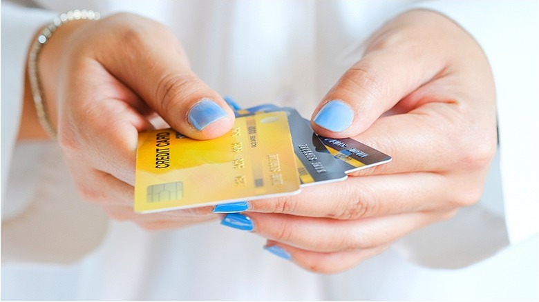 Hands holding several credit cards