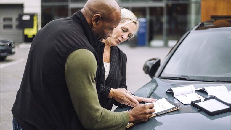 Consumer signing car buying documents