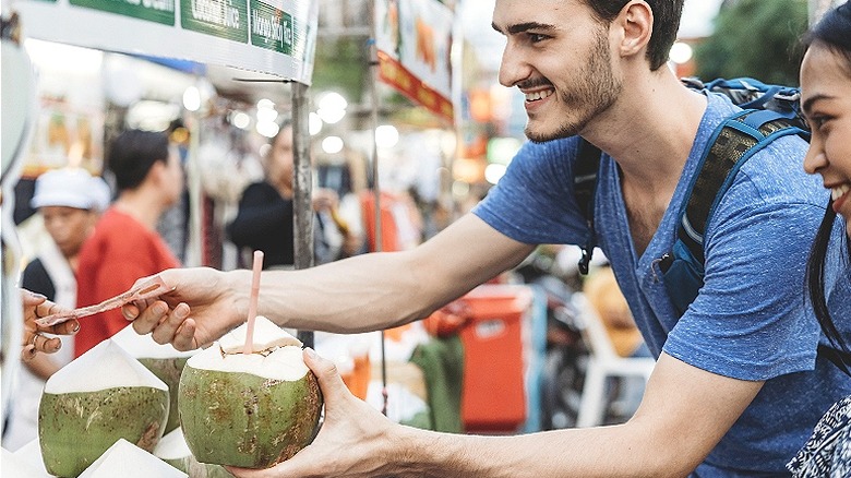 Person paying cash for street food